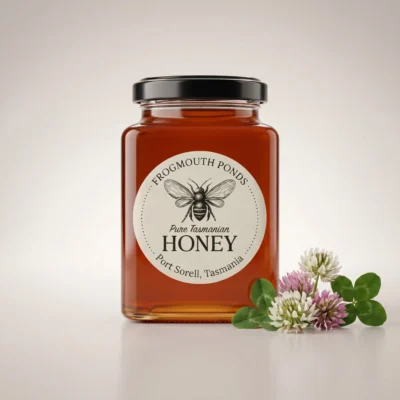Jar of Frogmouth Ponds pure Tasmanian clover honey, light golden colour, black lid and cream label, Port Sorell Tasmania