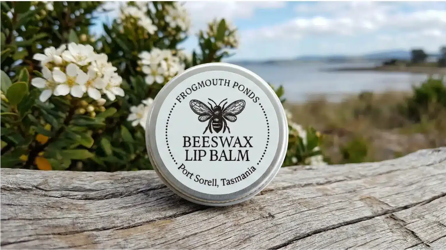 Beeswax balm tin on weathered timber above the water at Port Sorell